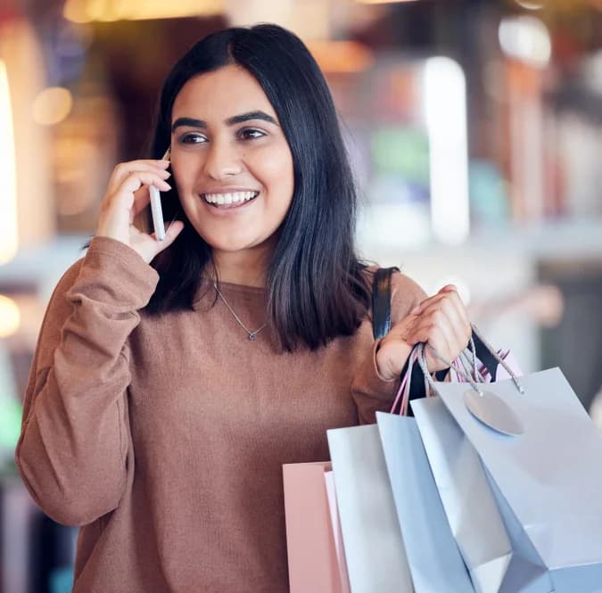 Customer carrying shopping bags while speaking on the phone